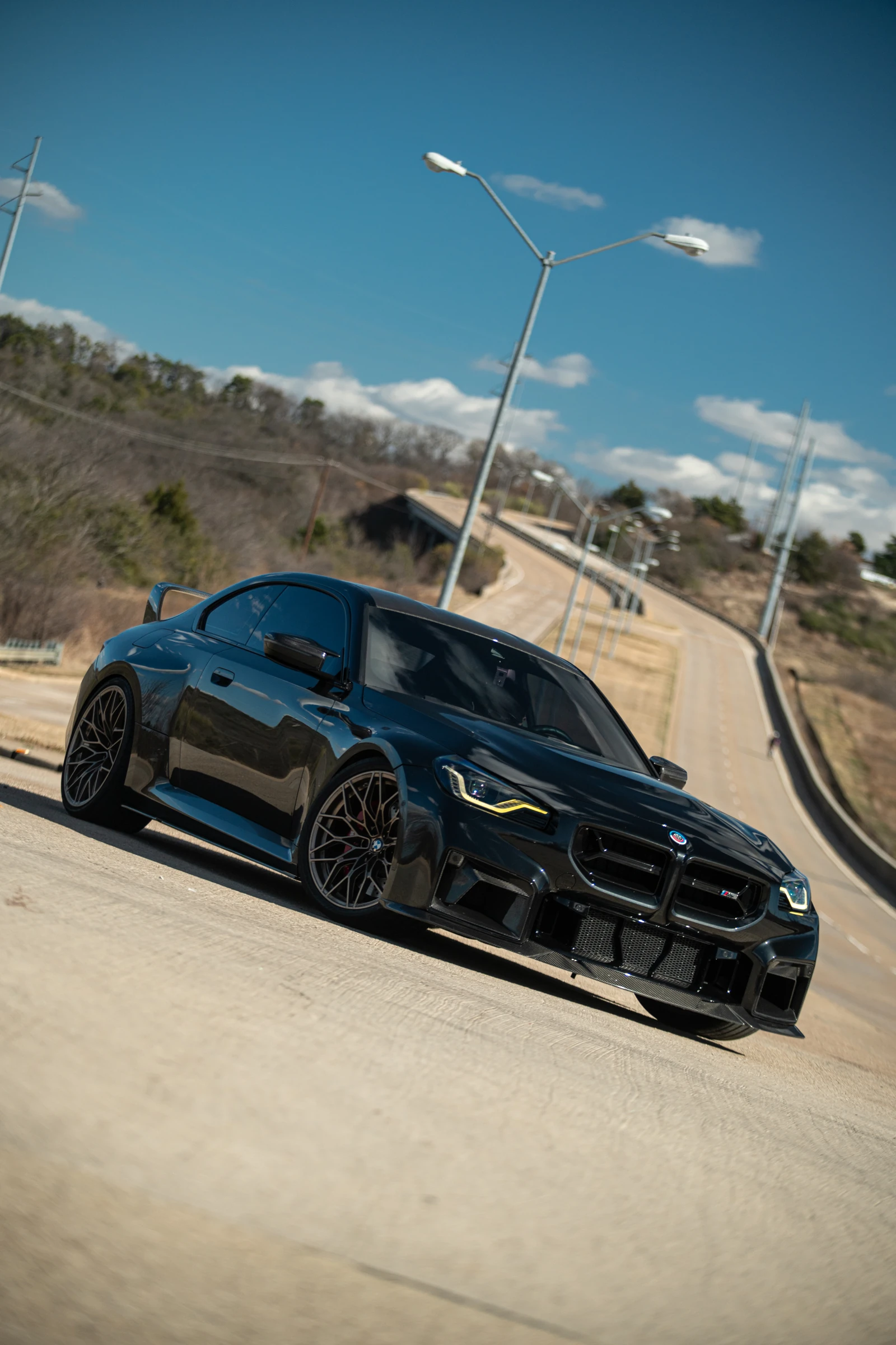 Low angle portrait of Erick’s black BMW M2